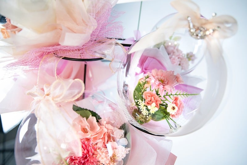 プレゼント仕様のセレモニーバルーンフラワー。ピンク色の花が透明なバルーンに包まれて華やかに飾られている様子