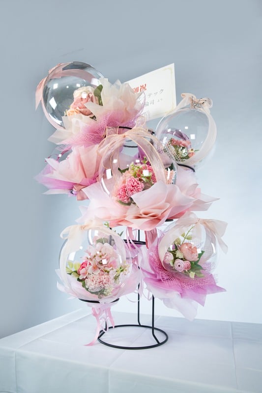 ピンク系のバルーンフラワータワー。やさしいピンク色の花とリボンで彩られた可愛らしいギフトアレンジ