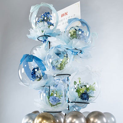 開封後にそのまま飾られた青と白の花が入ったバルーンタワー。足元には金銀のバルーンが飾られている。